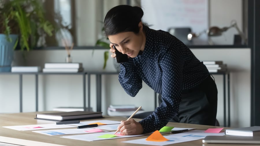 young-woman-office-on-phone-taking-notes