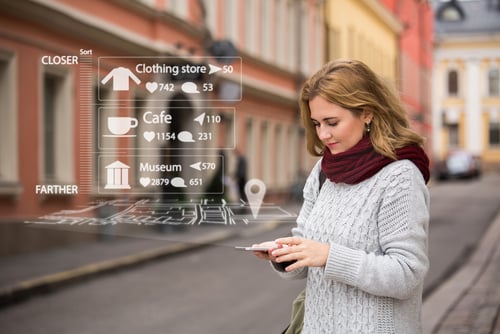 Young-woman-looking-at-phone-in-street