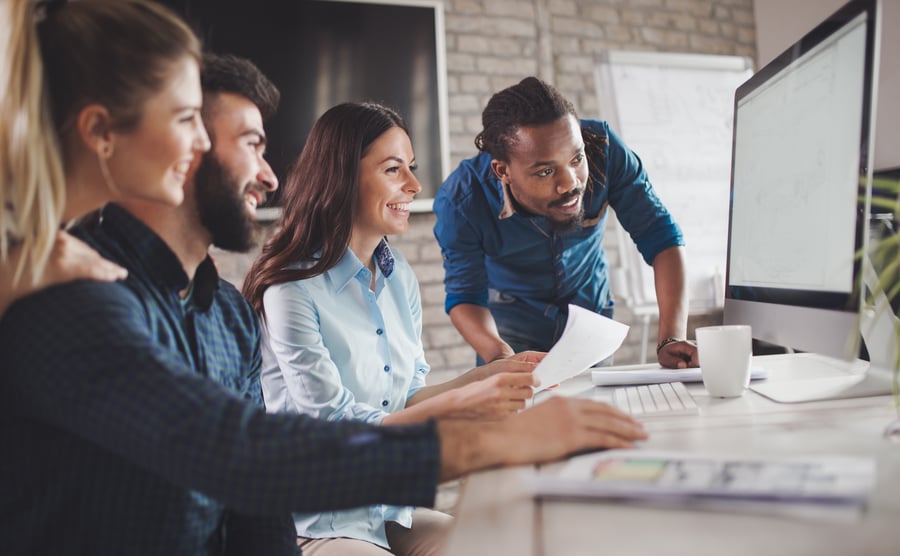 Young-work-team-smiling-looking-at-computer